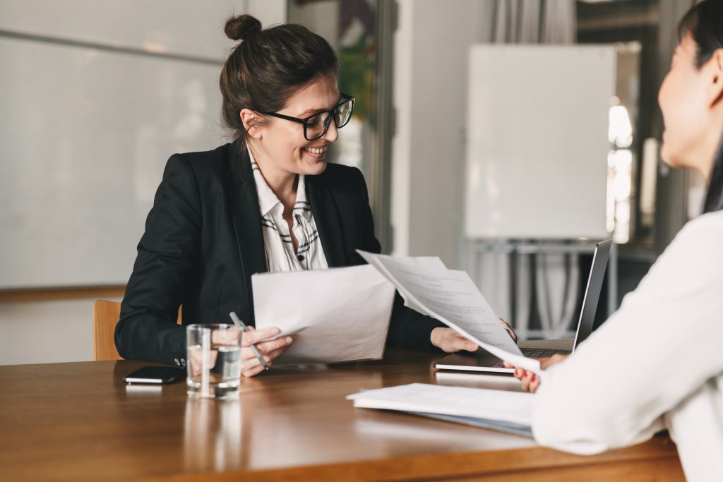 Female DfT lawyer holding papers in a meeting.