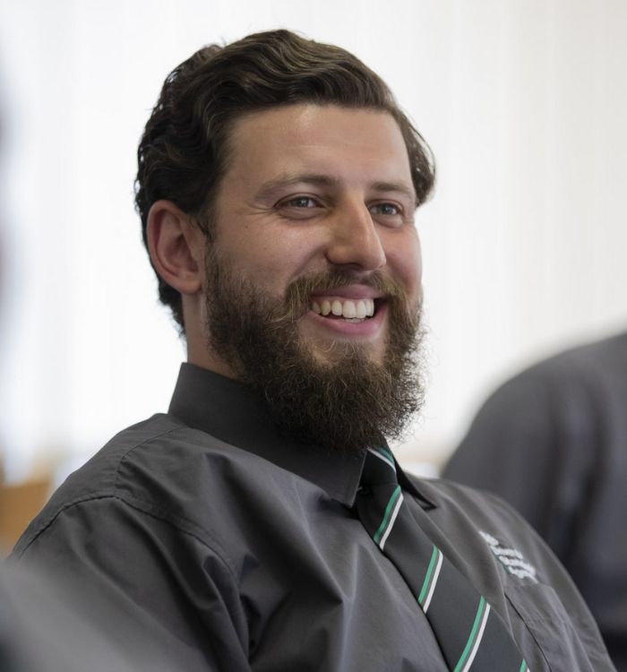 Dilshad Mahmud, DVSA member of staff, smiling among colleagues at the office.