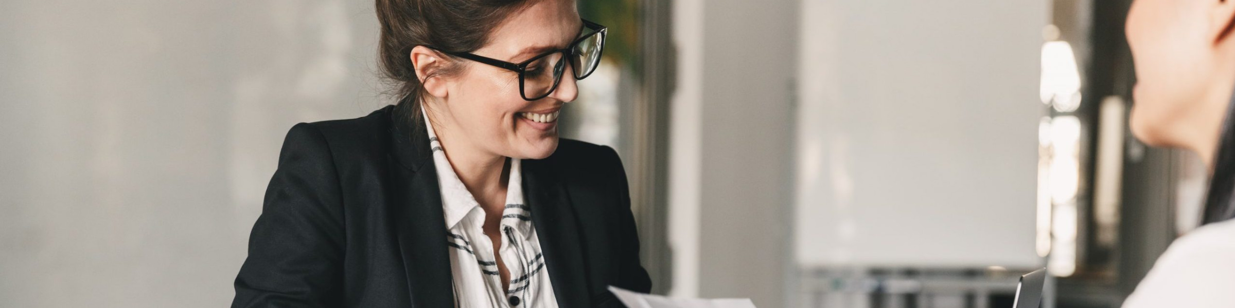 Female DfT lawyer holding papers and speaking to a colleague.